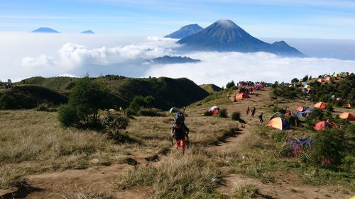 Hikers on mountain against volcano