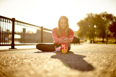 A portrait of a female runner stretching during her pre-run warmups.