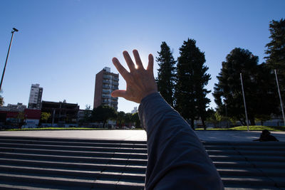 Midsection of man with arms raised against sky
