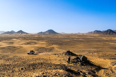Scenic view of desert against clear sky. jeep truck in scene