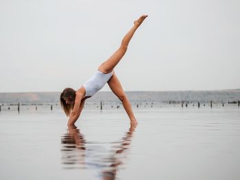 Full length of woman on beach against clear sky