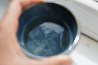 Cropped image of person holding black coffee