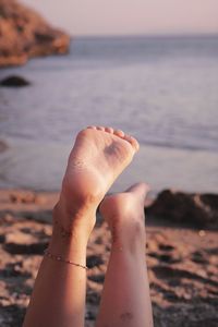 Low section of person relaxing on beach