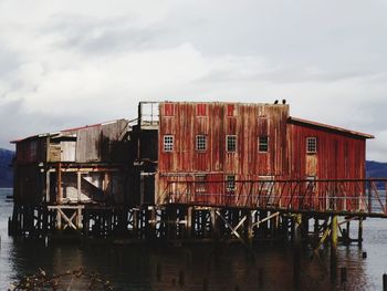 Built structure by sea against sky