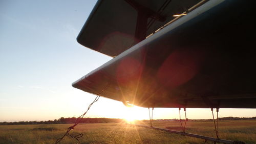 Hot air balloon on field against sky during sunset