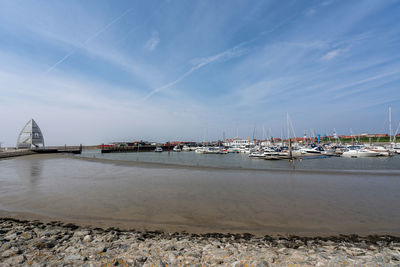 Sailboats on beach against blue sky