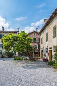 Street by buildings in town against sky