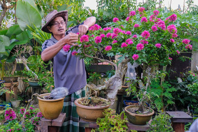 Woman standing by potted plants