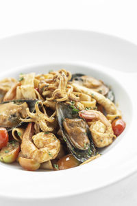 Close-up of food in plate against white background