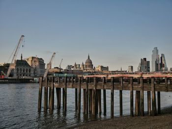 Pier on river against buildings in city