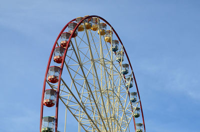 Low angle view of ferris wheel against blue sky