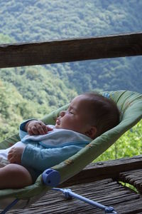 High angle view of boy sitting on railing