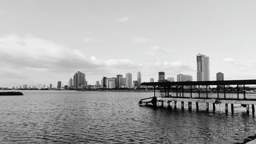 Scenic view of river by city against sky