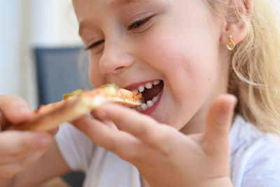 Close-up of girl eating pizza
