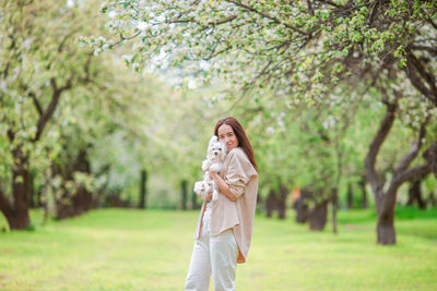 Woman standing by tree on field