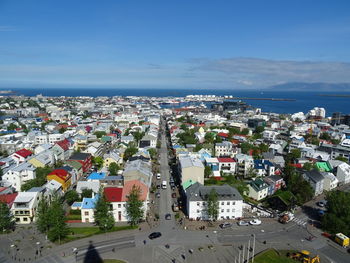 Aerial view of cityscape by sea against sky