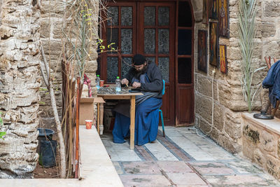 Side view of man sitting on table