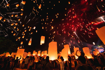 People watching firework display at night