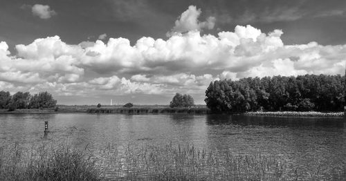 Scenic view of river against cloudy sky