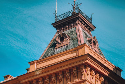 Low angle view of clock tower against blue sky