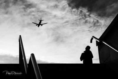 Low angle view of silhouette airplane against sky