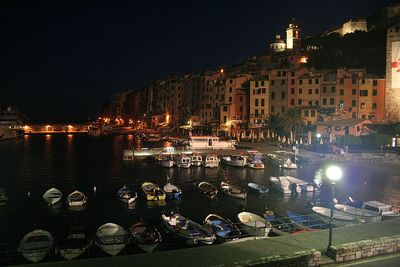 People sitting in illuminated city against clear sky at night