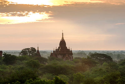 View of temple building against cloudy sky, sunrise 