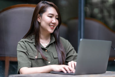 Young woman using laptop at cafe