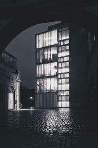 Illuminated building seen through arch