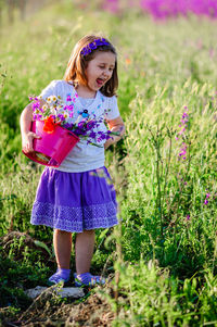 Full length of a girl holding pink flower