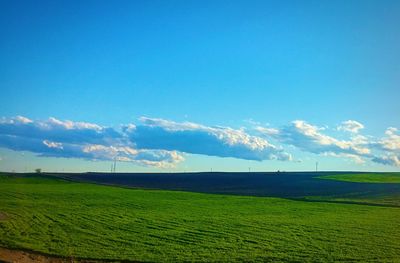 Scenic view of grassy field against cloudy sky