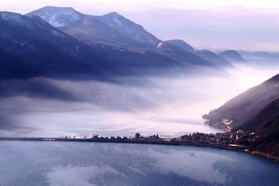 Scenic view of lake by mountains against sky