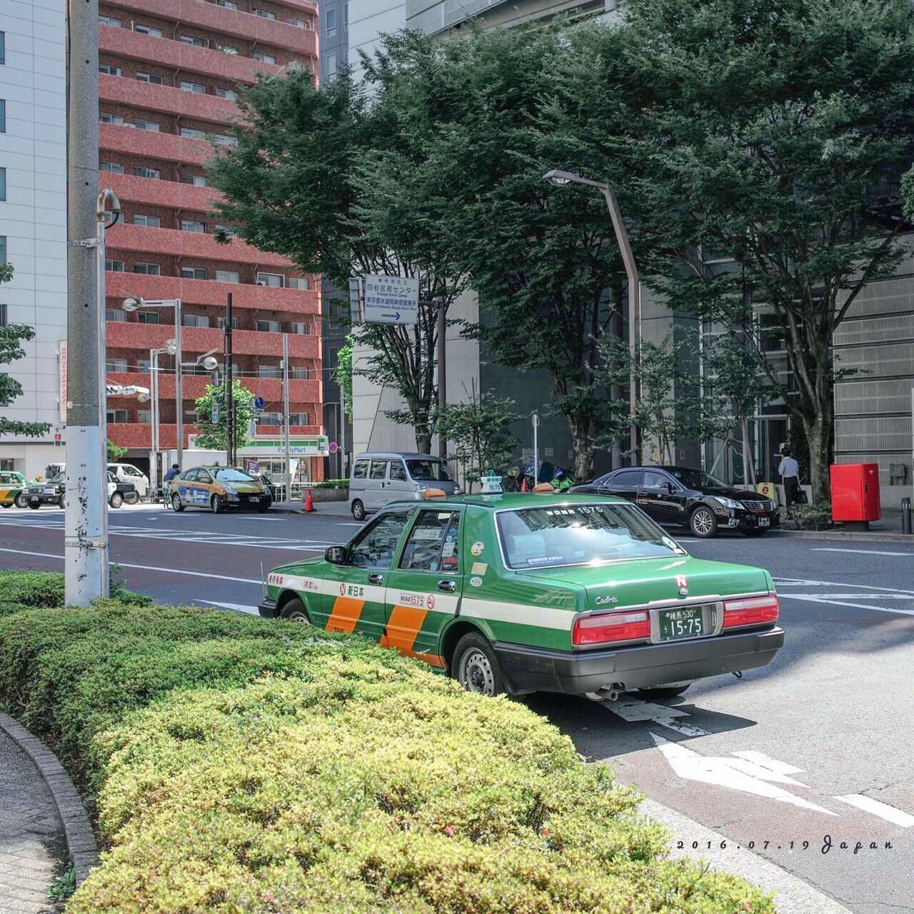 land vehicle, architecture, built structure, mode of transport, tree, city, road, growth, parking, day, outdoors, city street, stationary, parked, green color, no people, plant, city life, grass, nature