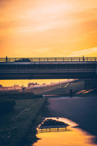 Bridge over road against sky during sunset