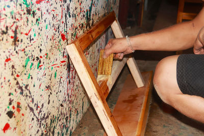 High angle view of woman hand painting on wood