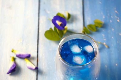 Close-up of blue flower in glass container on table