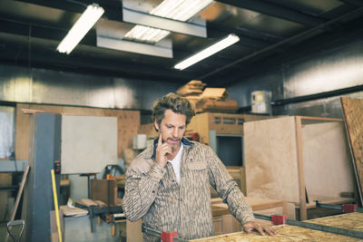 Thoughtful carpenter working at workshop