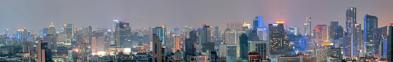 Panoramic view of illuminated city buildings against sky