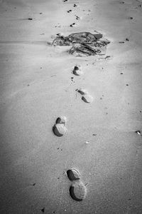 High angle view of footprints on sand at beach