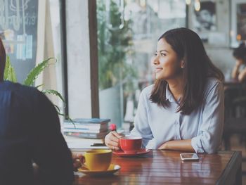 Close-up of woman sitting on table at cafe