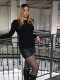 Portrait of a beautiful young woman standing against railing