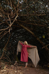 Rear view of woman standing in forest