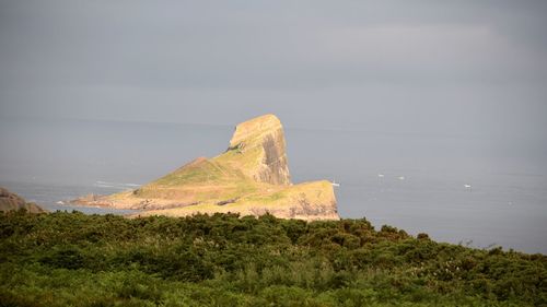 Rock formations by sea against sky