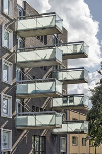 Low angle view of balconies in city against sky