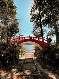 Footbridge over railroad tracks against clear sky