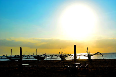 Silhouette beach against sky during sunset