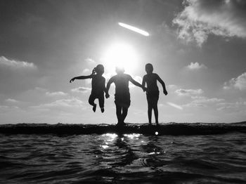 People enjoying at beach against sky