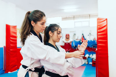 Taekwondo teacher guiding student during martial arts practice