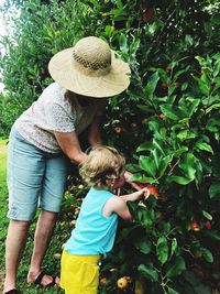 Woman standing with granddaughter by plants