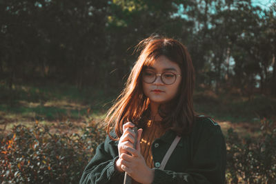 Portrait of beautiful young woman standing on field